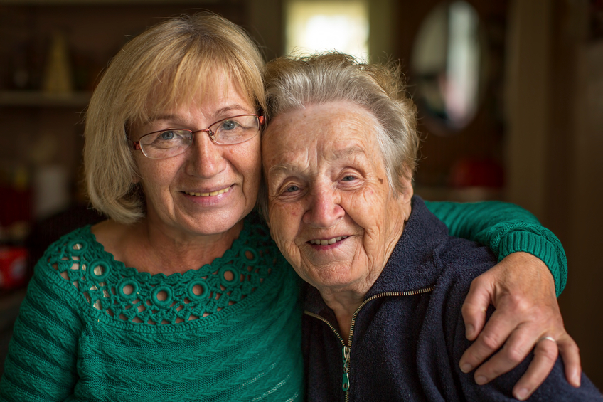 Two elderly women hugging